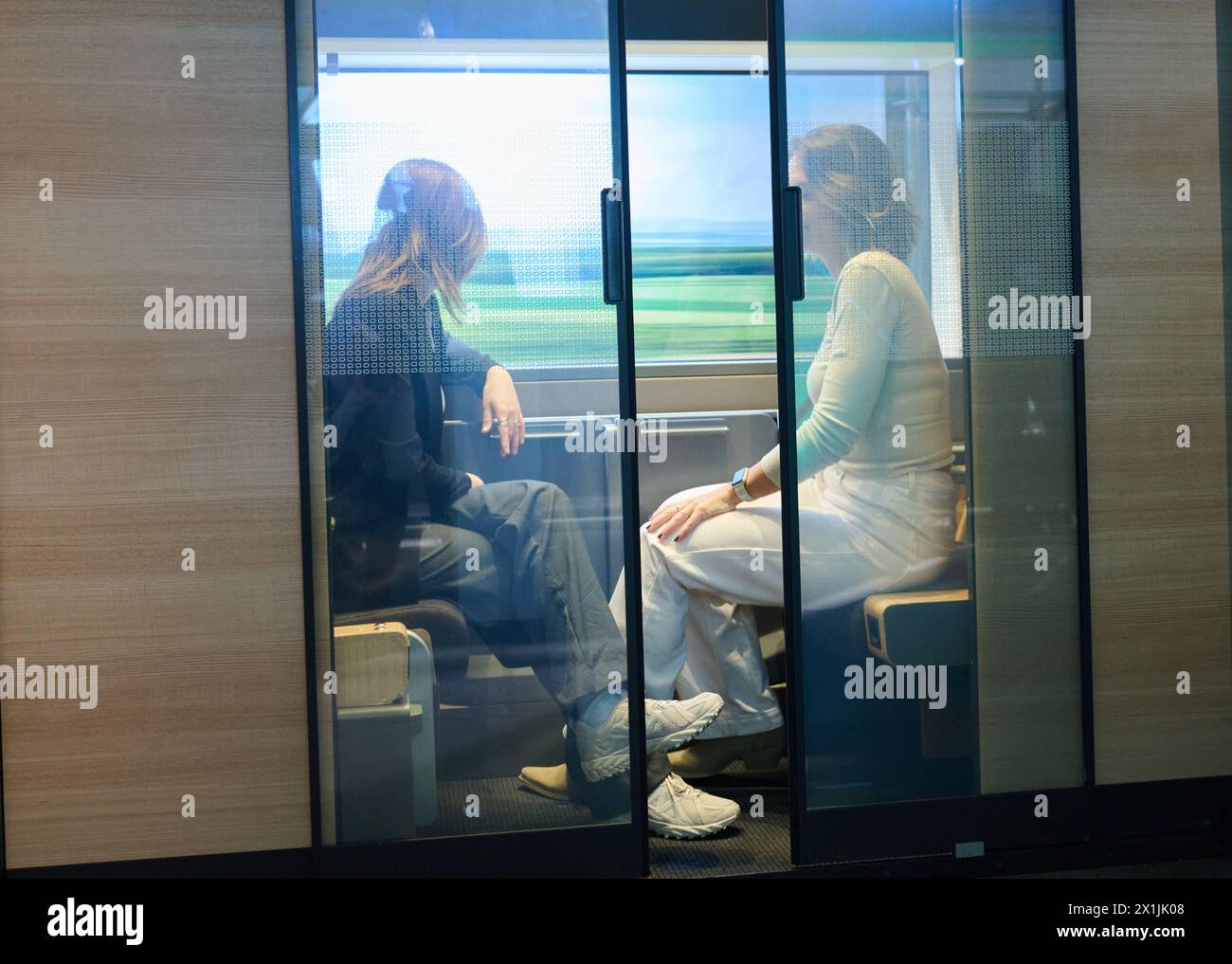 17 April 2024, Berlin: Two Deutsche Bahn employees sit in a two-person ...