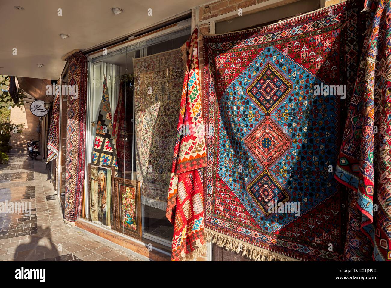 Colorful Persian carpets displayed outside of a local carpet shop in the New Julfa, Armenian Quarter of Isfahan, Iran. Stock Photo