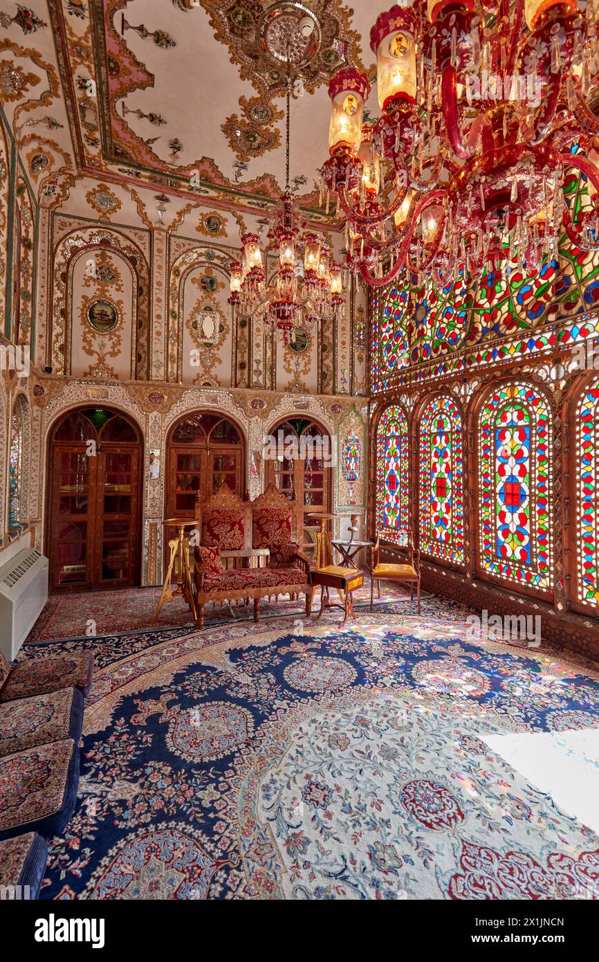 Ornate interior of the reception hall (shahneshin) with large colorful stained glass windows in Mollabashi Historical House in Isfahan, Iran. Stock Photo