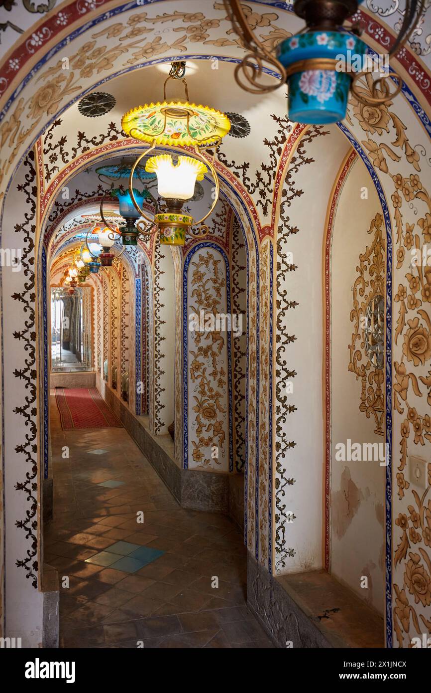 Ornate corridor with arched ceiling and retro style colorful lamps in the Mollabashi Historical House. Isfahan, Iran. Stock Photo