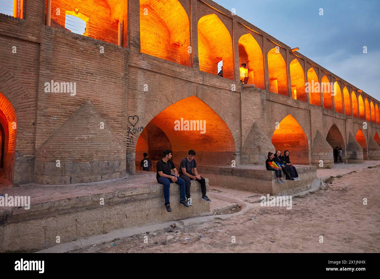 Zayanderud People sit on the Allahverdi Khan Bridge, aka Si-o-se-pol (17th century ...
