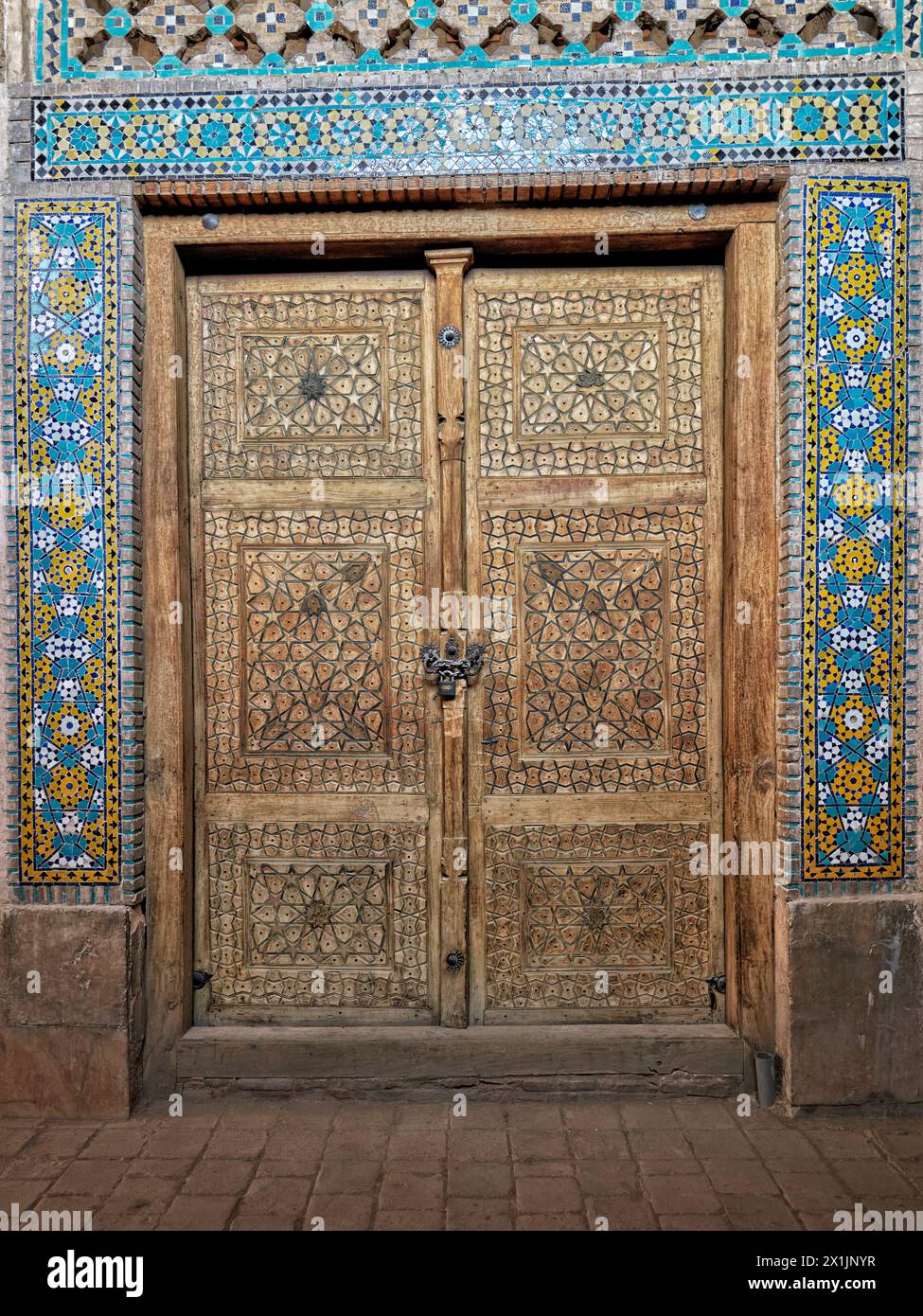 Closed old wooden door covered with intricate carvings in the Jameh Mosque of Isfahan, one of the oldest mosques in Iran. Isfahan, Iran. Stock Photo