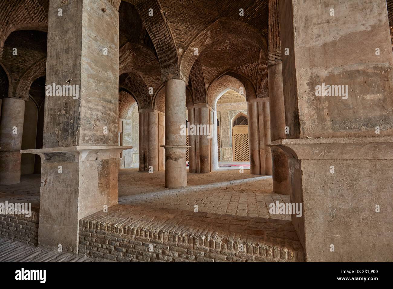 Interior view of hypostyle hall with many pillars supporting roof of brick vaults in the Jameh Mosque of Isfahan, Iran. Stock Photo
