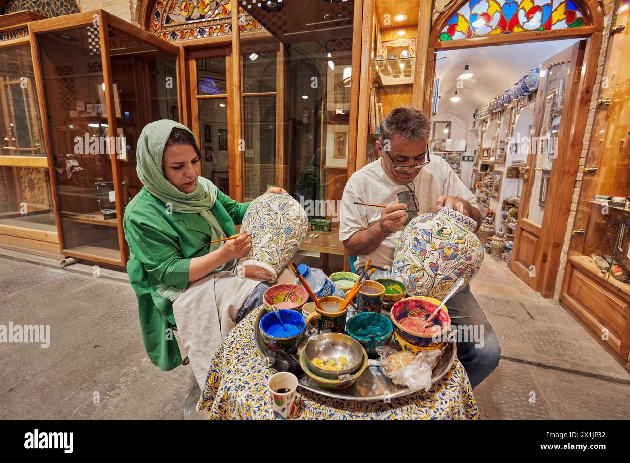 Iranian artisans hand paint large ceramic pots before final glazing. Grand Bazaar, Isfahan, Iran. Stock Photo