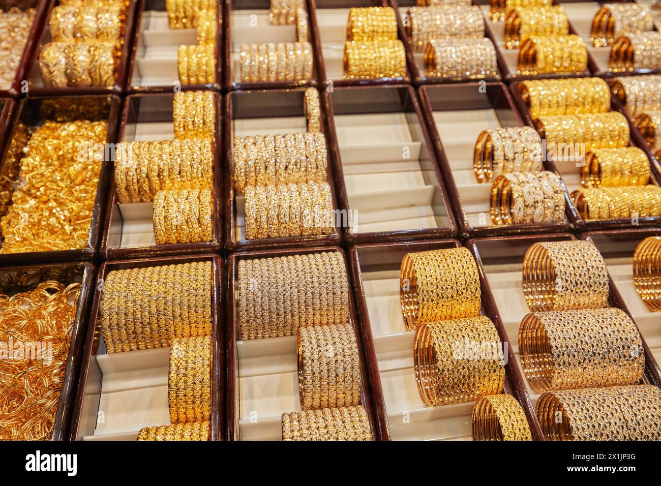 A selection of golden bracelets displayed in a jewelry store window in the Grand Bazaar of Isfahan, Iran. Stock Photo