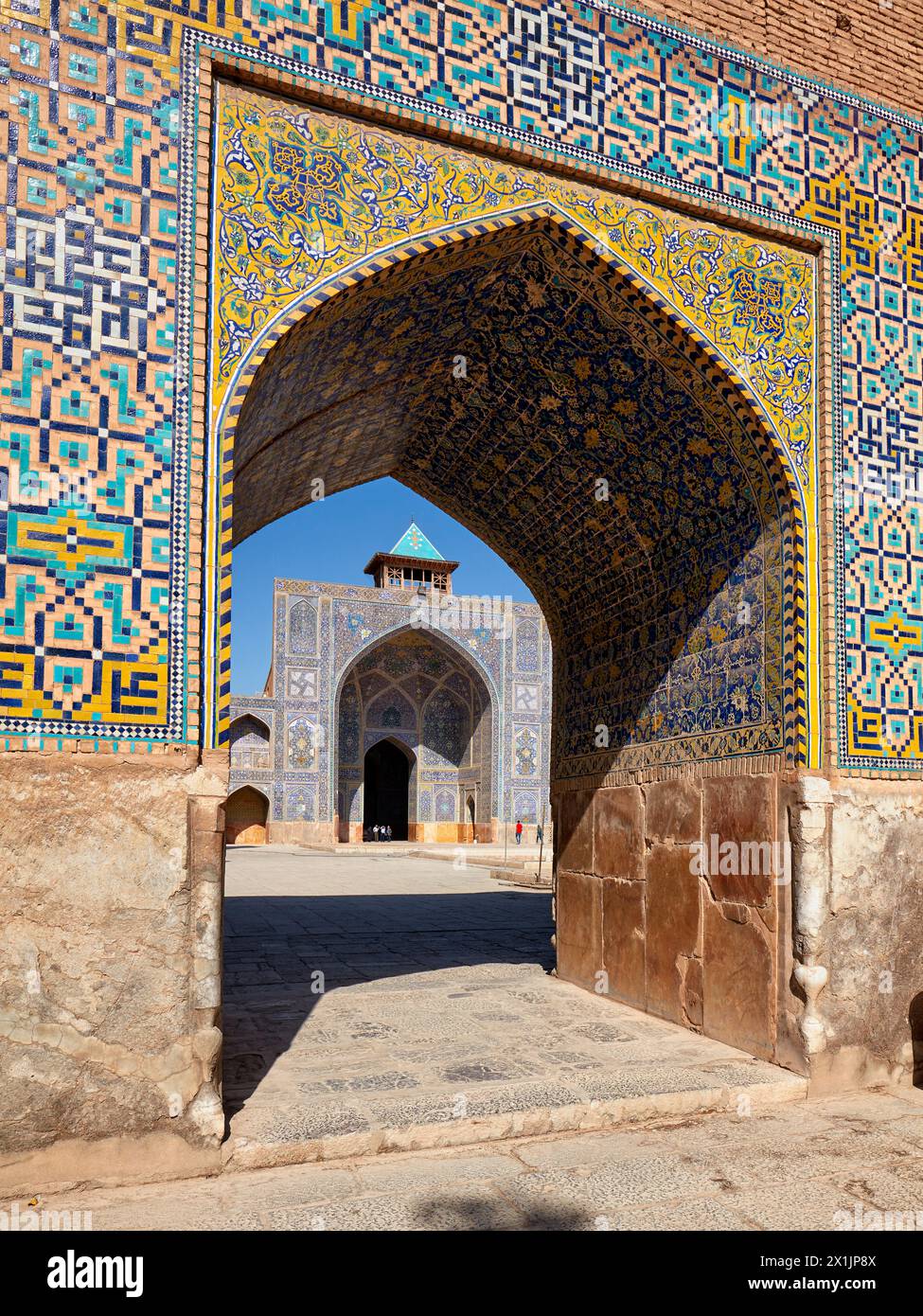 Courtyard view of the Shah Mosque (Masjed-e Shah) through an arch with elaborate tilework. Isfahan, Iran. Stock Photo