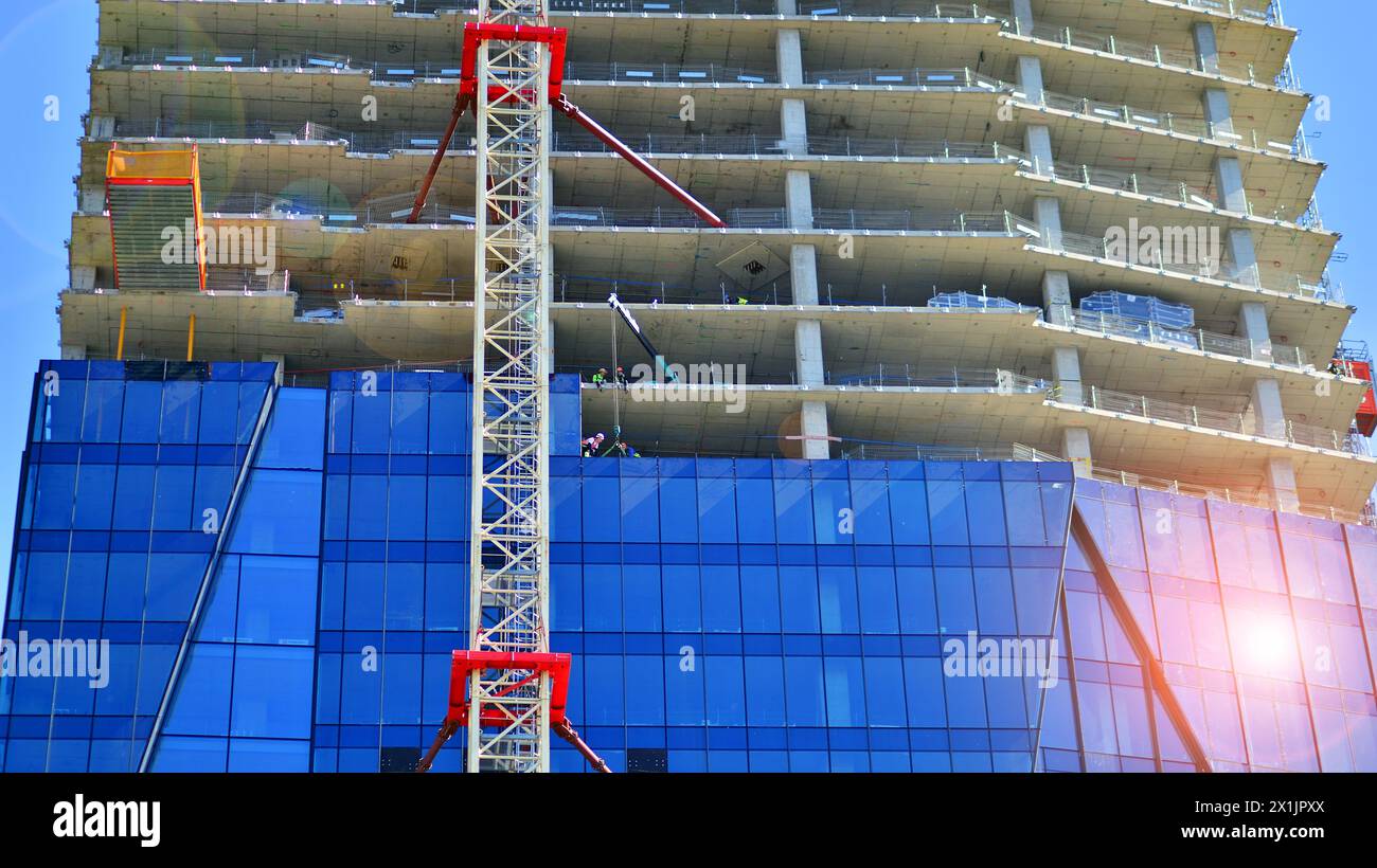 High rise building under construction. Installation of glass facade ...