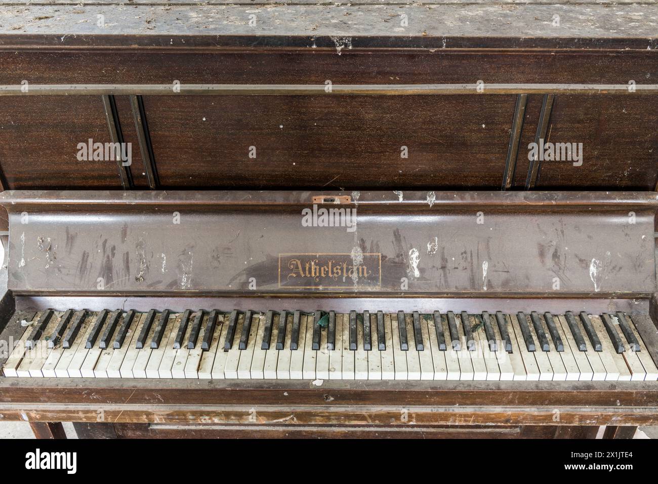 An old abandoned Athelstan upright piano found in a derelict building, London, UK Stock Photo
