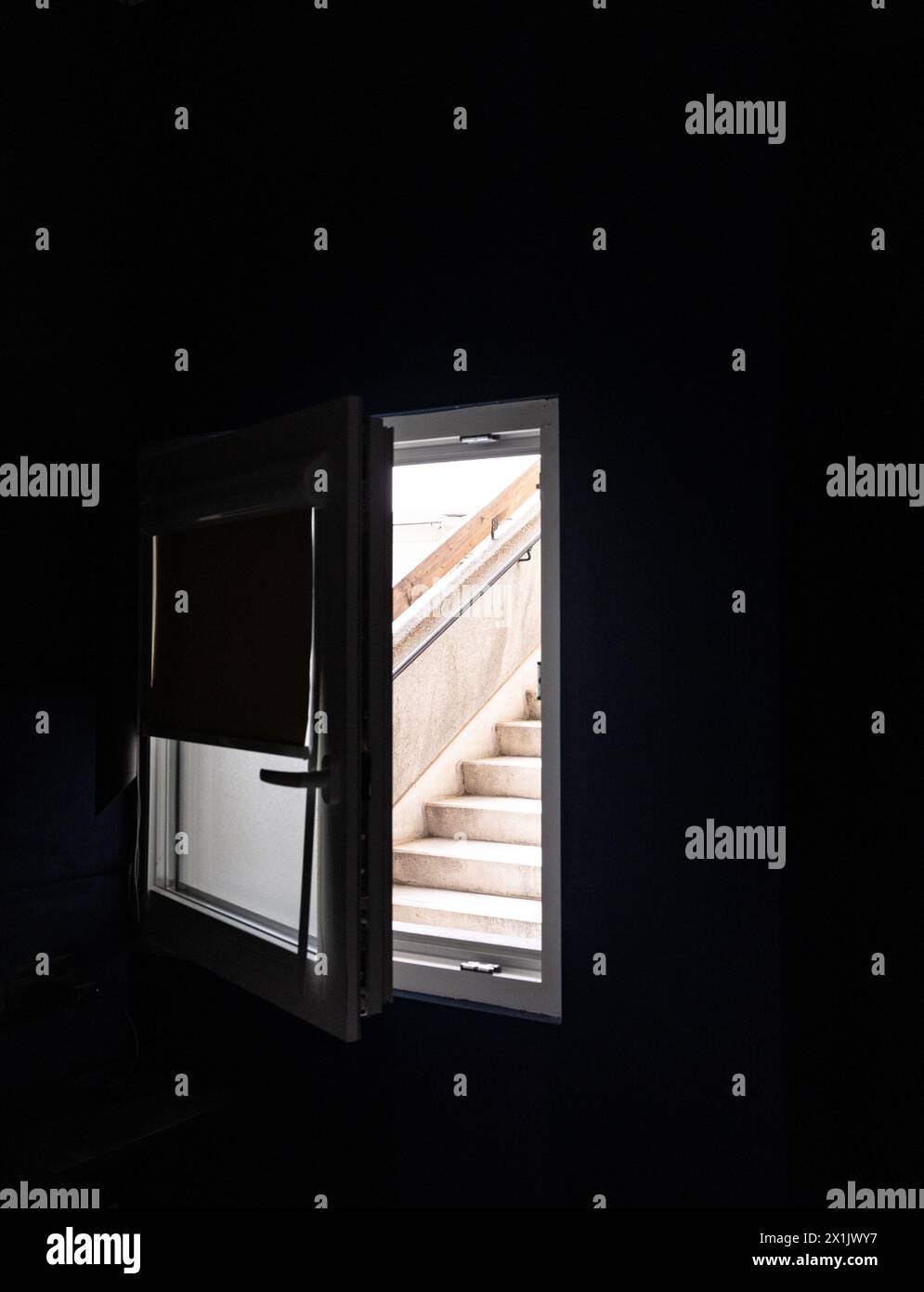 Concrete steps through a bedroom window in a bleak apartment block. Stock Photo