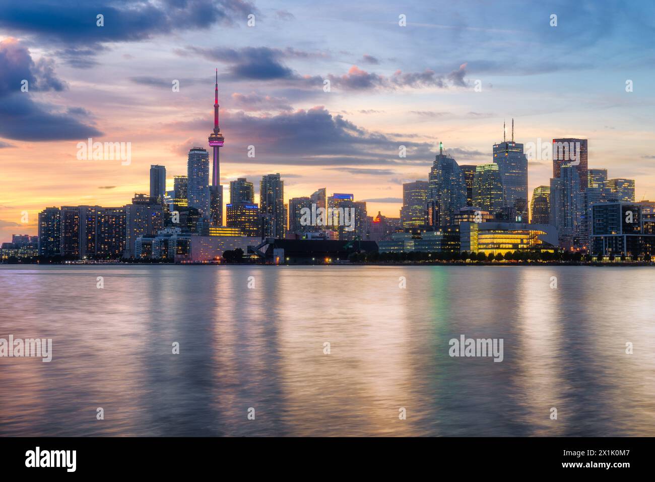 Toronto cityscape panorama at dusk over lake with colorful light ...