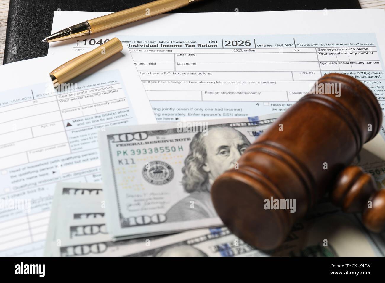 Tax return forms, dollar banknotes, gavel and pen on table, closeup Stock Photo