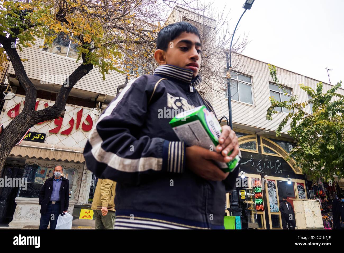 Shiraz, Iran- December 31, 2022: The people of Iran. An Afghan immigrant teenager sells imported chewing gum on the street. Westernization. A preferen Stock Photo