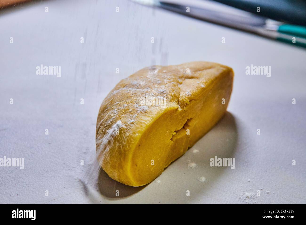 Homemade Pasta Dough Half Wedge with Flour Dusting in Action Stock Photo