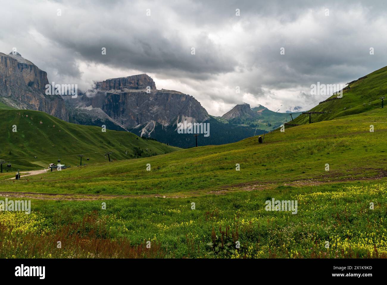 Dolomites mountains in Italy - Sella mountain ridge from meadows above Sella pass during cloudy summer day Stock Photo
