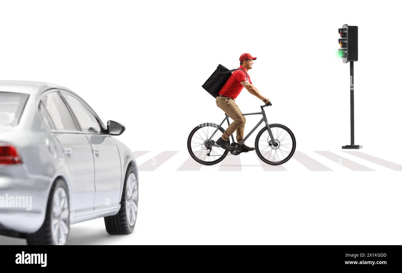 Delivery guy in a red t-shirt delivering food with a bicycle, crossing a road at a pedestrian zebra sign isolated on white background Stock Photo