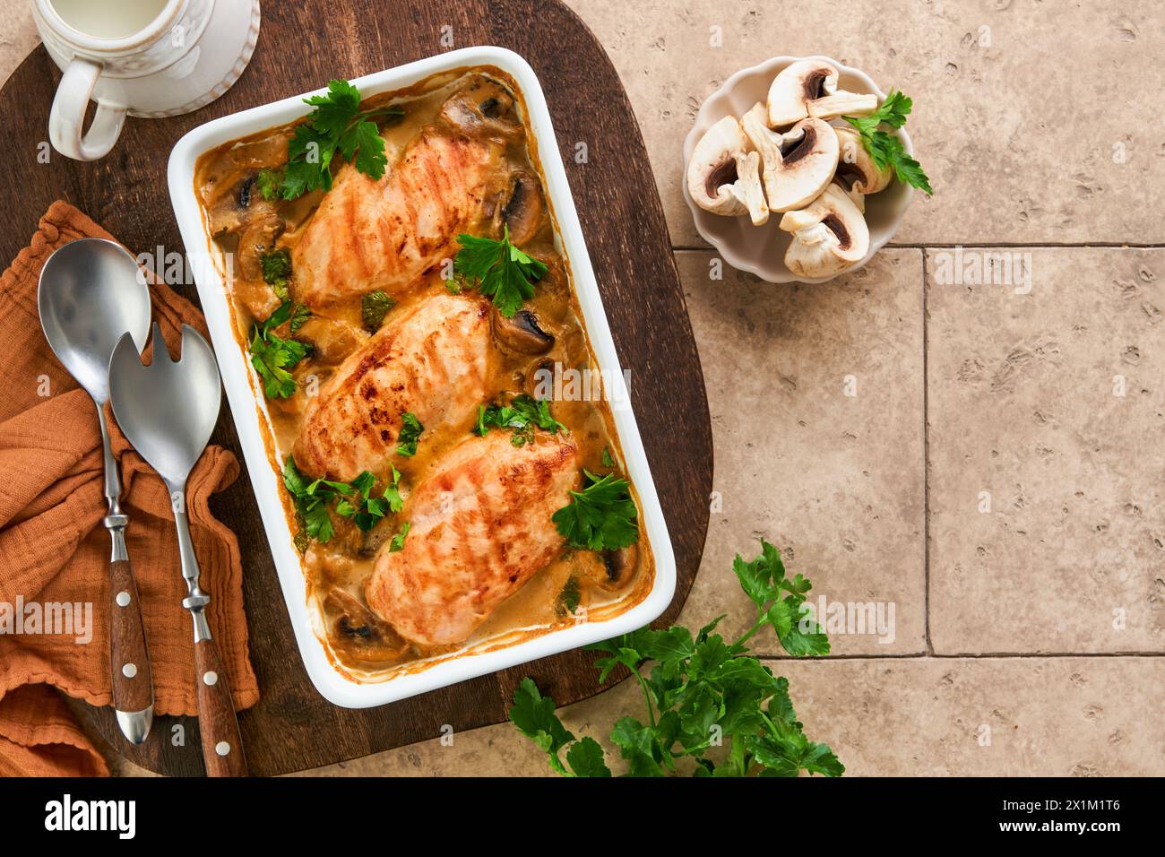 Baked chicken breast bbq with mushrooms and garlic in cream sauce on old brown concrete tilestable backgrounds. Top view image with ingredients for co Stock Photo