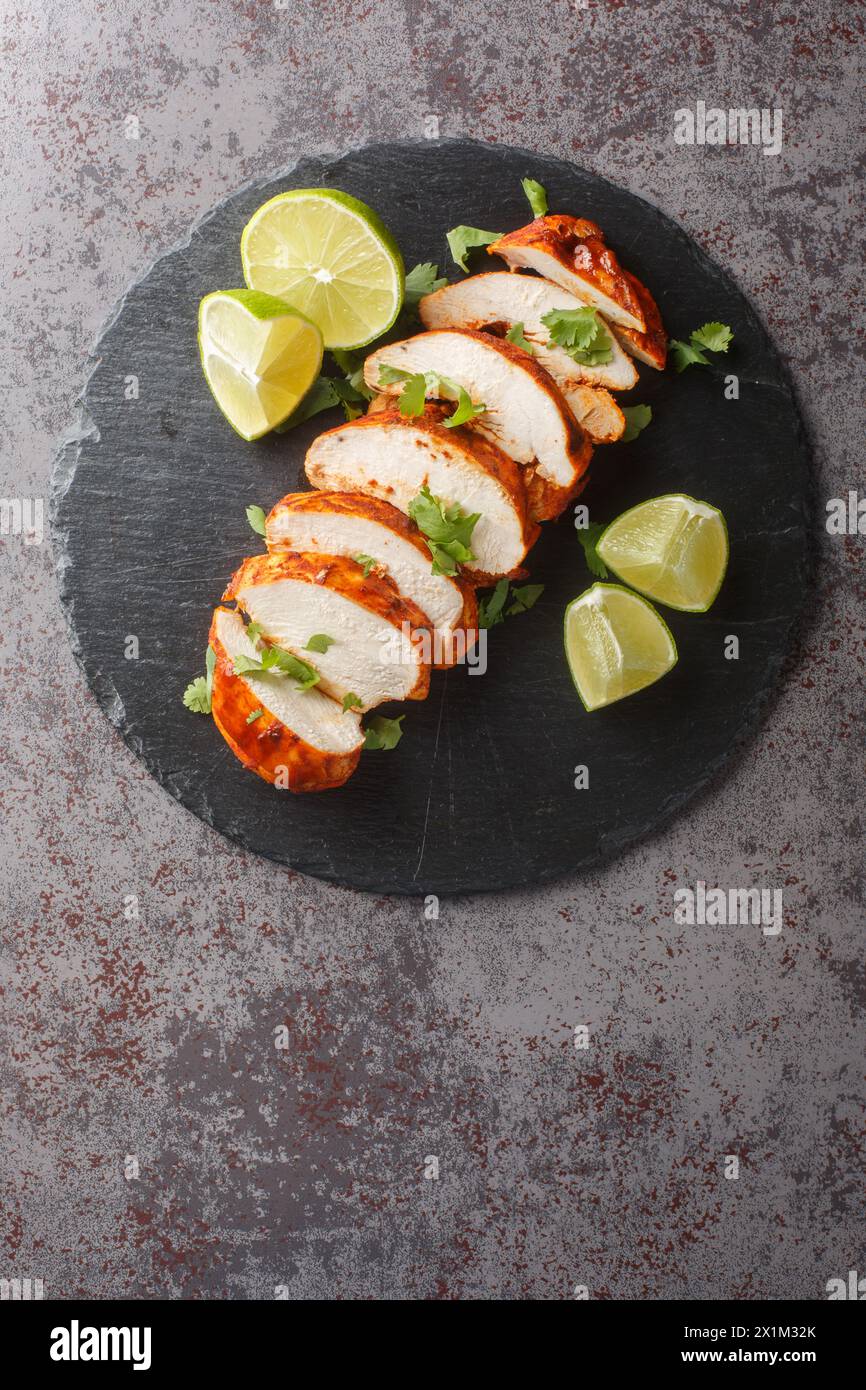 Homemade Grilled Chipotle Chicken Breast with Cilantro and LIme closeup on a slate plate on the table. Vertical top view from above Stock Photo