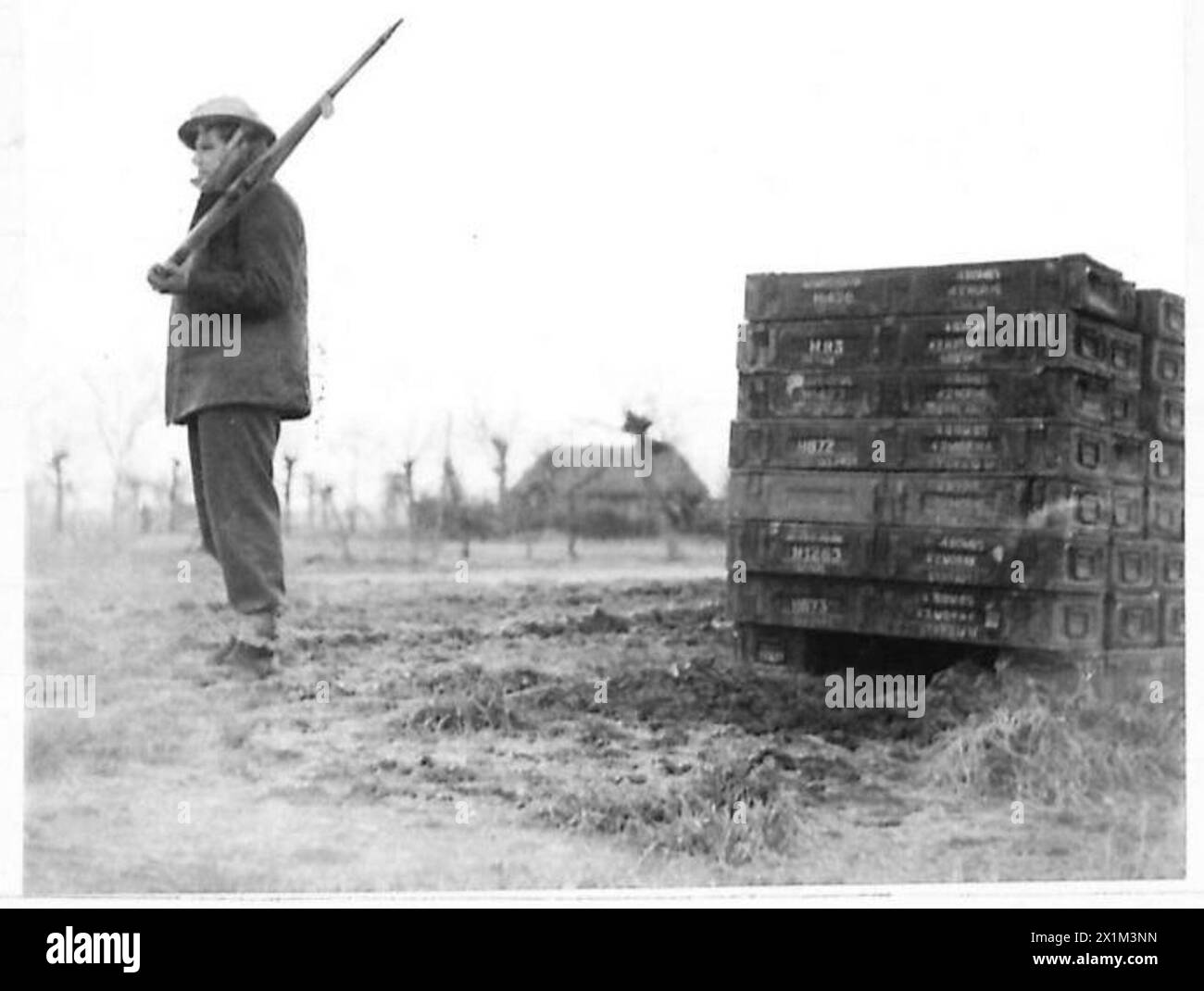 EIGHTH ARMY VARIOUS A sentry stands guard beside a pile of