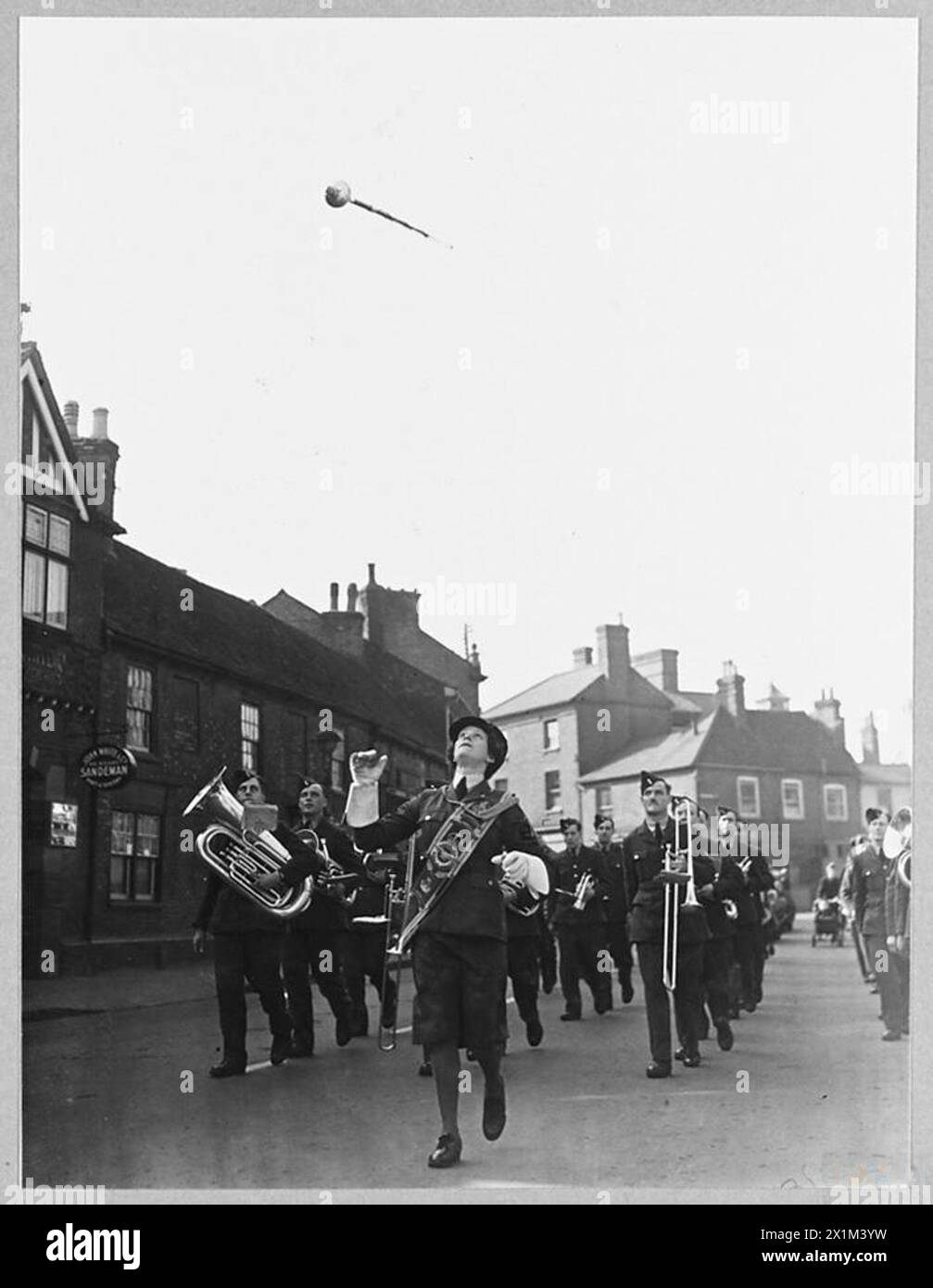 R.A.F. 25TH ANNIVERSARY PARADE IN HOME COUNTIES - W.A.A.F. drum major of an R.A.F. band throws her mace high into the air. The band headed the march past. [LACW M.Dorrington], Royal Air Force Stock Photo