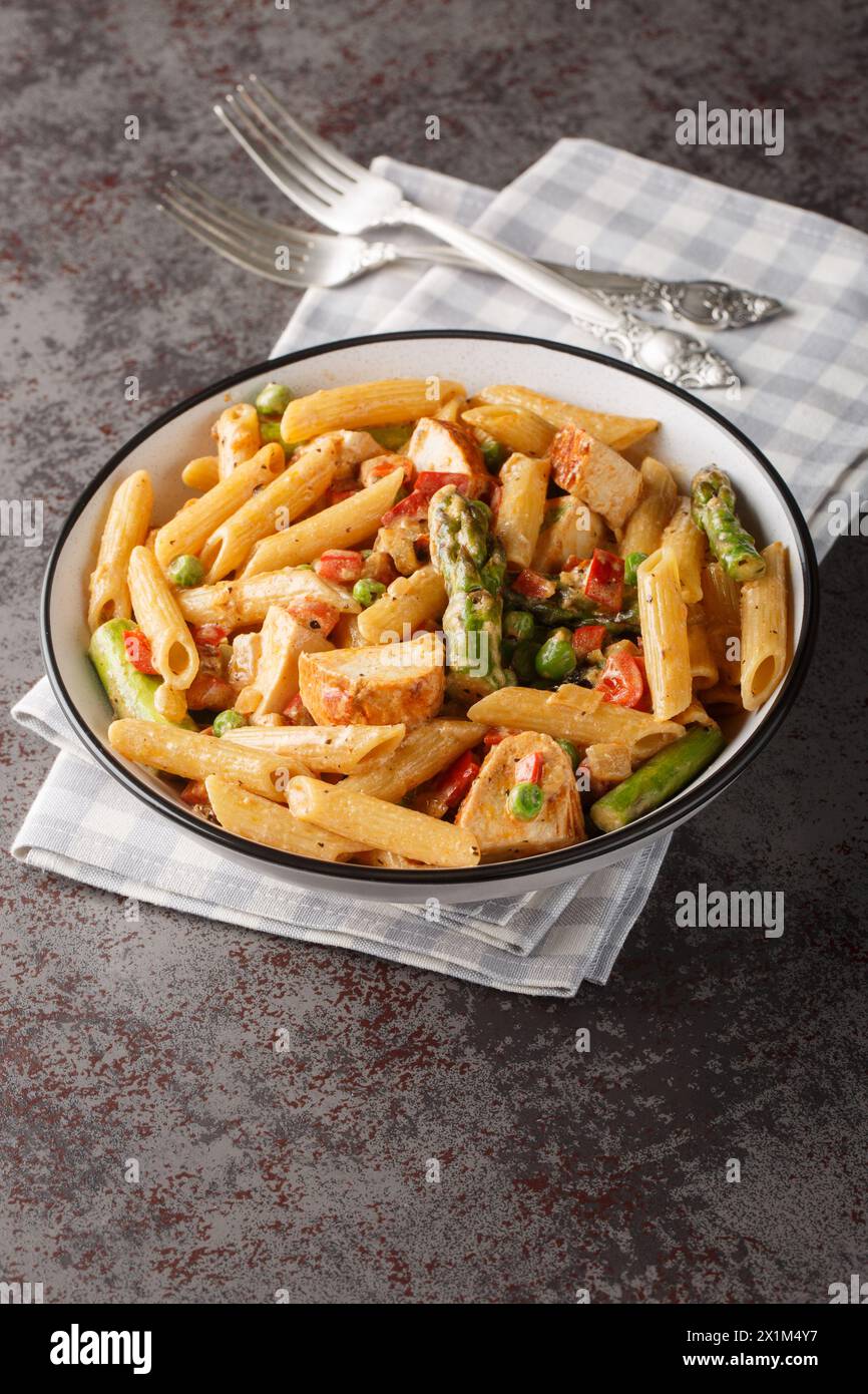 Mexican Creamy Chicken Chipotle Pasta with vegetables closeup in the bowl on the table. Vertical Stock Photo