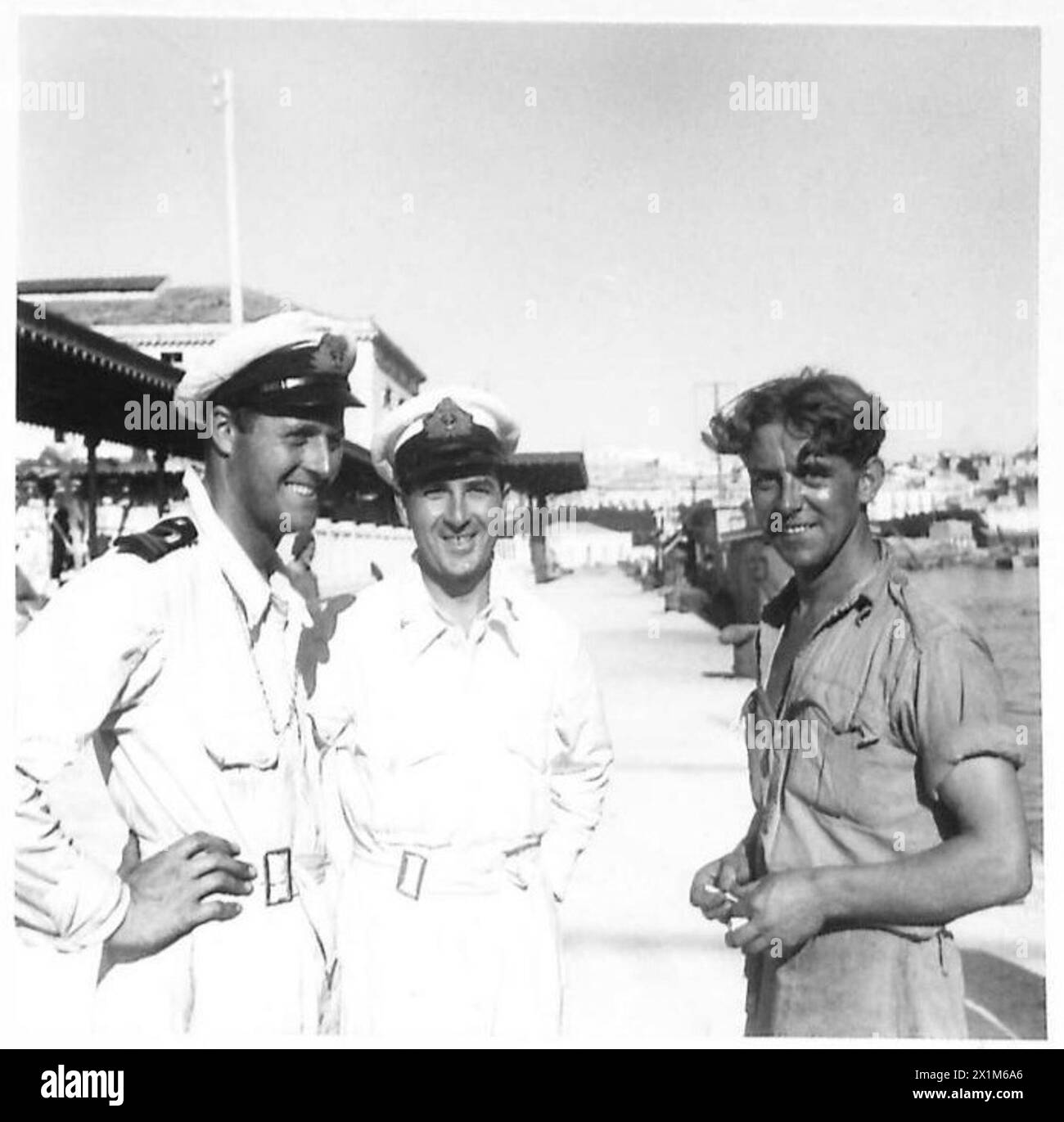 INVASION OF SICILY H.M. FLEET SWEEPER 'SEAHAM' CAPTURES ITALIAN SUB. - Left to right: - 1st Lieut. W.S. Daswon R.N.V.R., of Glasgow chats to Lieut. C.H. Sharp, R.N.V.R., of Oxford, navigator and officer of the 'Watch', who sighted the submarine when it first surfaced and gave orders to ram her. The vessel crashed as Seaman C. Mooney of Sheffield who was lookout on the Seaham and confirmed the sighting of the U Boat, British Army Stock Photo