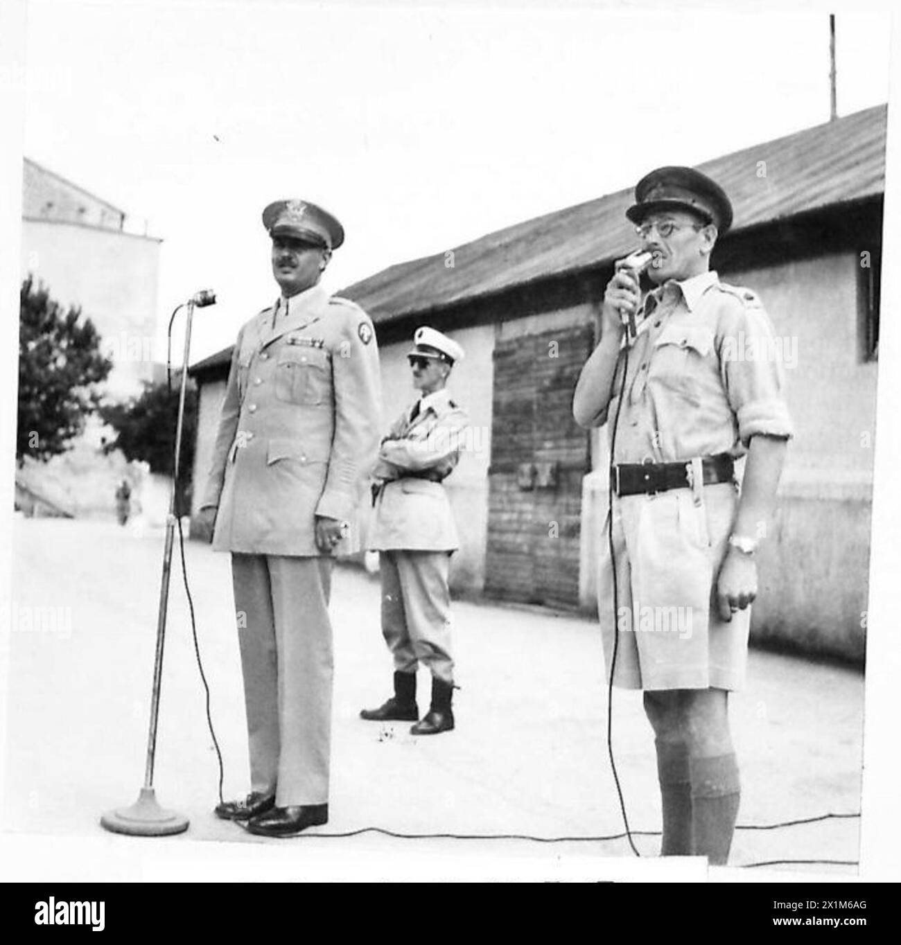 S.C.A.O. ADDRESSES NEWLY ENROLLED V.G. POLICE - Col. Alfred C. Bowman addressing the parade, with the assistance of Major J. Henderson (in shorts) who interpreted through a second microphone, British Army Stock Photo
