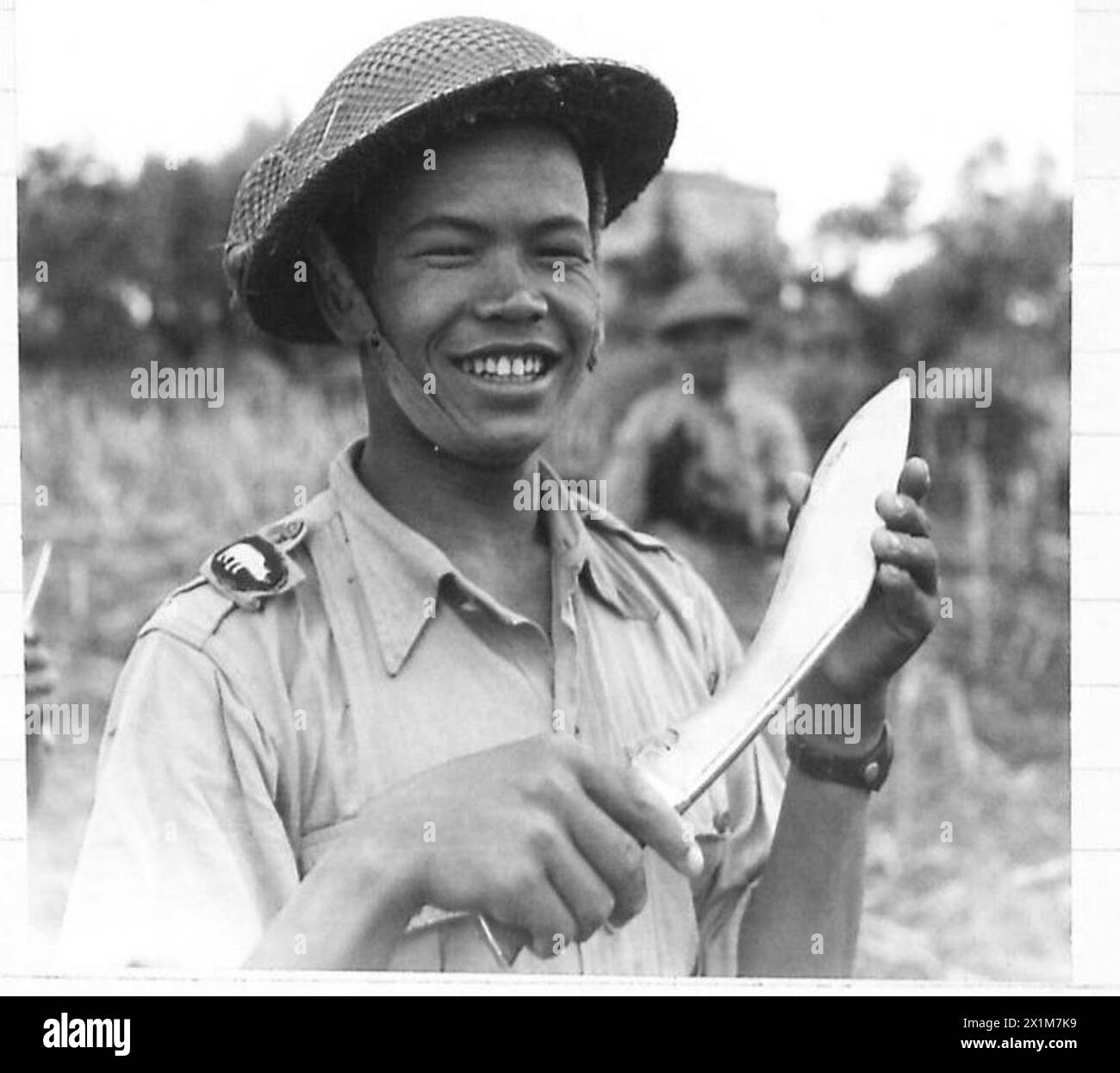 EIGHTH ARMY ADVANCE - A Gurkha tries the keen edge of his kukri before