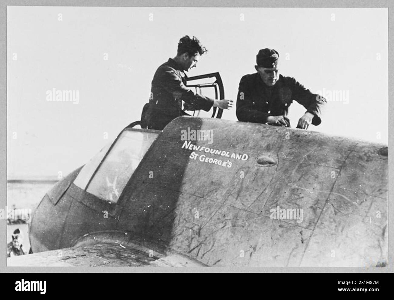 R.A.F. BEAUFIGHTERS NAMED AFTER NEWFOUNDLAND PROVINCES AND TOWNS [NEWFOUNDLAND SQUADRON] - Two of the ground crew servicing 'ST.GEORGE'S' - a named Beaufighter. Corporal G.Marsh from Grand Falls (left), and LAC John Martin, harness maker from Bell Island, Royal Air Force Stock Photo