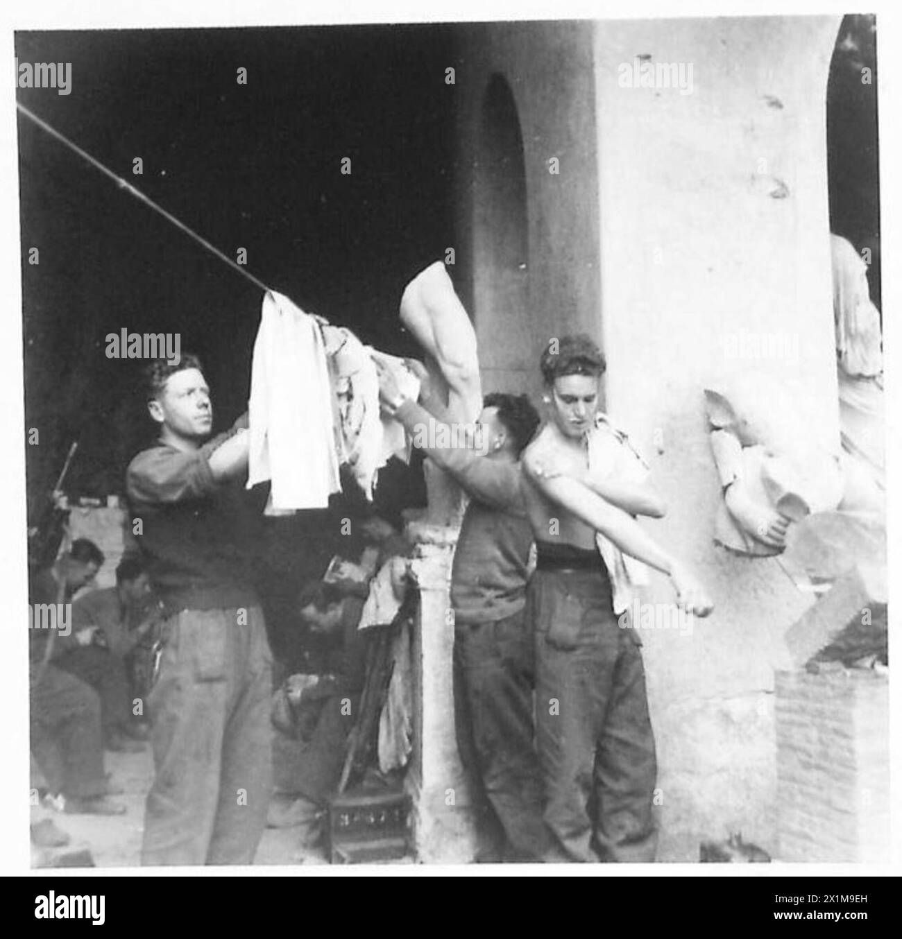 THE BRITISH ARMY IN NORTH AFRICA, SICILY, ITALY, THE BALKANS AND AUSTRIA 1942-1946 - Rfn. A. Forster of Purley, Frn. B. Joel of Norwood, Rfn. S. Rason of Holloway, London hanging up some clothing to dry, British Army Stock Photo