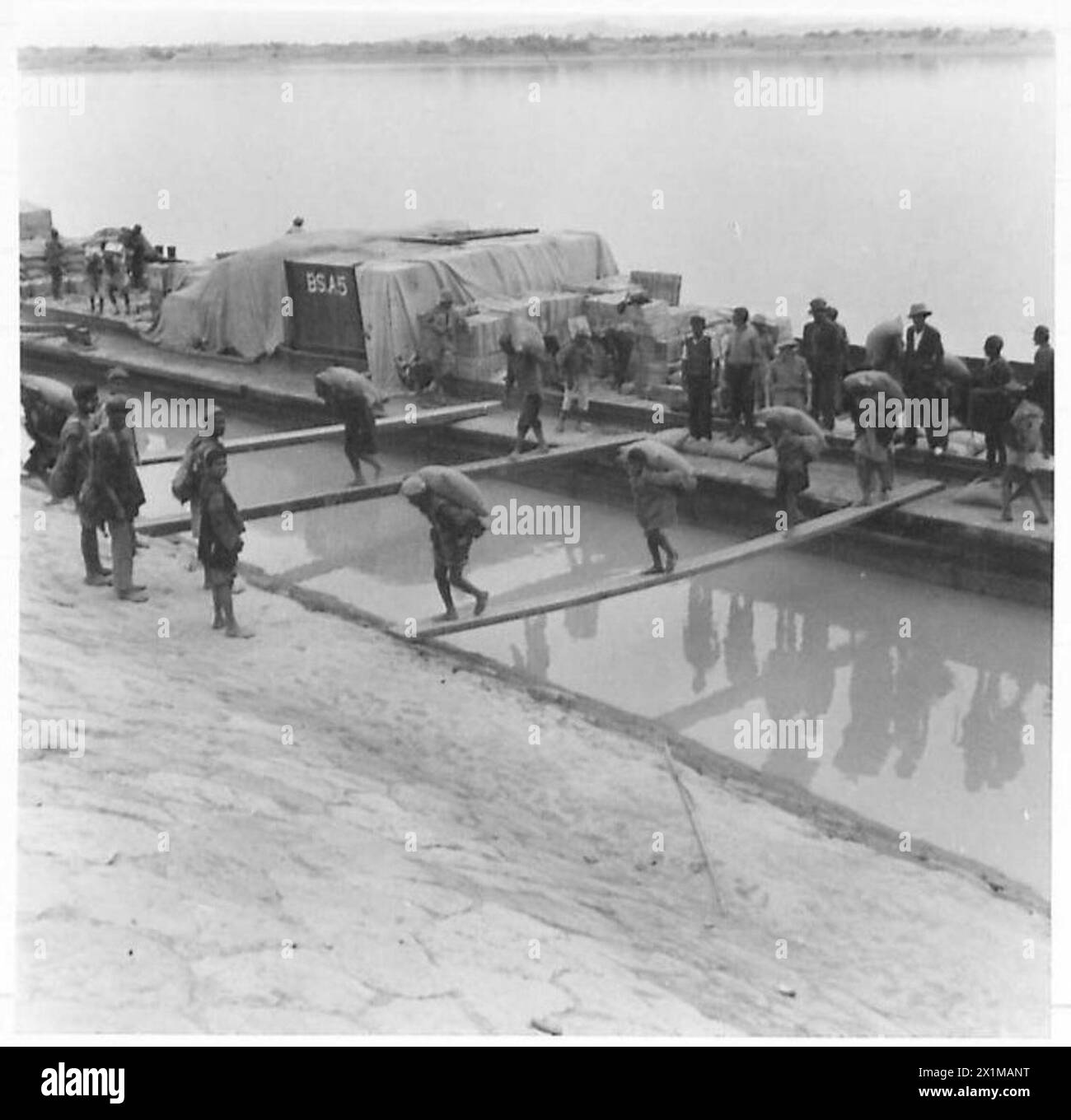 SUPPLIES TO RUSSIA - Grain and stores are herebeing unloaded at Ahwaz, having travelled by barge up the Karune river from Kharramshah and Bushire. At Ahwaz the stores are trans-shipped into box vans and transported to Russia, British Army Stock Photo