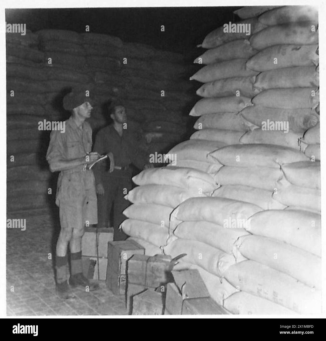 ITALY : THE FEEDING OF ROME - Pte. B. Stamford (left) of Beacon House, Clifton Maltby, Rotherhan, and Pfc. L. Tradewell of Boston, Mass., USA checking up the flour in the Central Railway Station, Rome, British Army Stock Photo