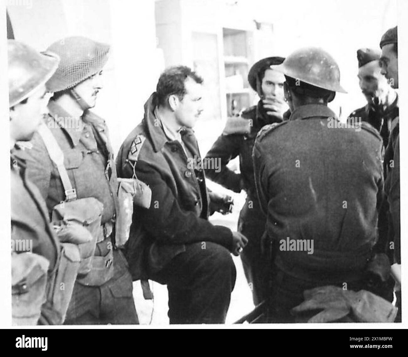 ITALY : EIGHTH ARMY ENTRY INTO ORTONA - Tank operations were held up by a mine exploding in the main streer. Lieut P.R.V. Carr-Harris of Kingston, Ontario, Royal Canadian Engineers, explains the situation to Capt. Blair of the Edmonton Regiment, British Army Stock Photo