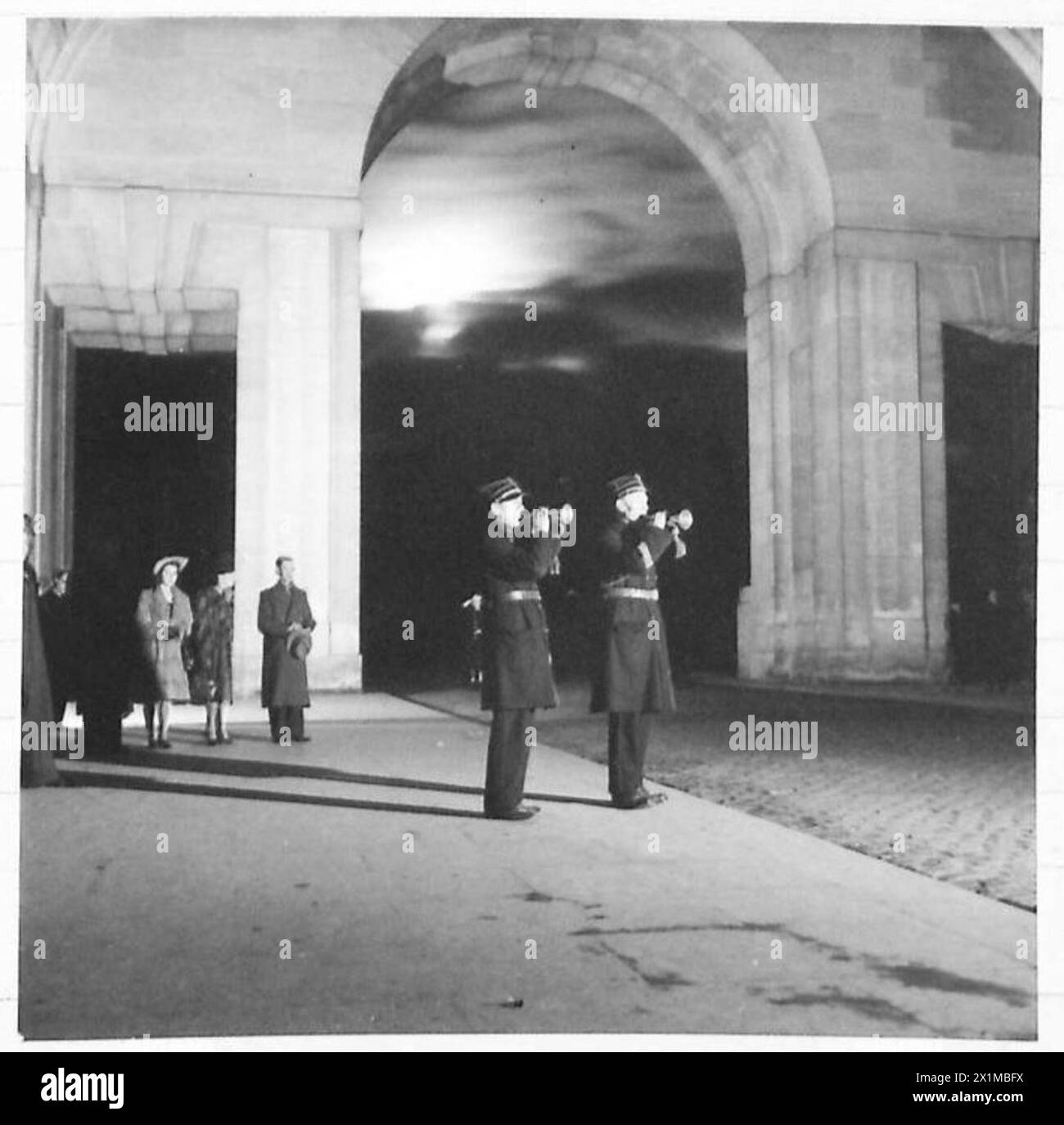 THE LAST POST CEREMONY AT THE MENIN GATE, YPRES. - The Last Post has been sounded at the Menin Gate Ypres, ever since the Memorial was erected, until the Germans invaded Belgium. The Belgiums then stopped the nightly ceremony on 10th May, 1940. Ypres was liberated on the 6th Sept, 1944. and the Ceremony was restarted on the 7th Sept, 1944. The Last Post is sounded at the Menin Gate at 20.00 hrs. in the Winter and 21.00 hrs in the Summer, every evening. The two men sounding the Last Post are M. Leon De. Groot, and M.G. Both are members of the Ypres Fire Brigade, at the present time assisting in Stock Photo
