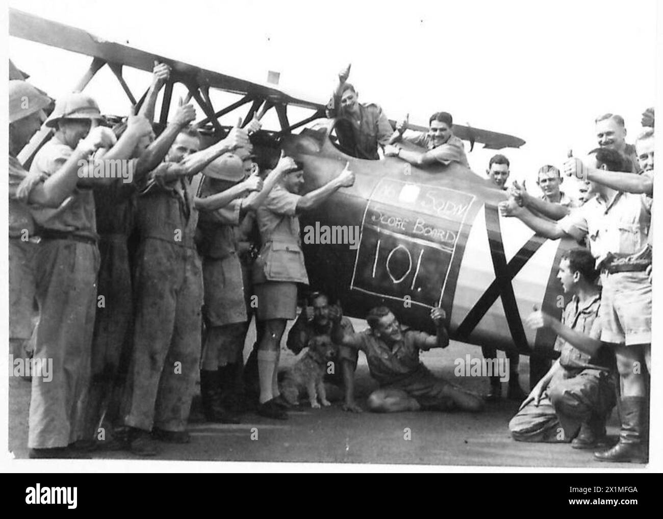 PICTURES TAKEN WITH THE SOUTH AFRICAN AIR FORCE - Thumbs up' and three cheers after the score of the squadron has been chalked up on a captured Italian C.R.42, British Army Stock Photo