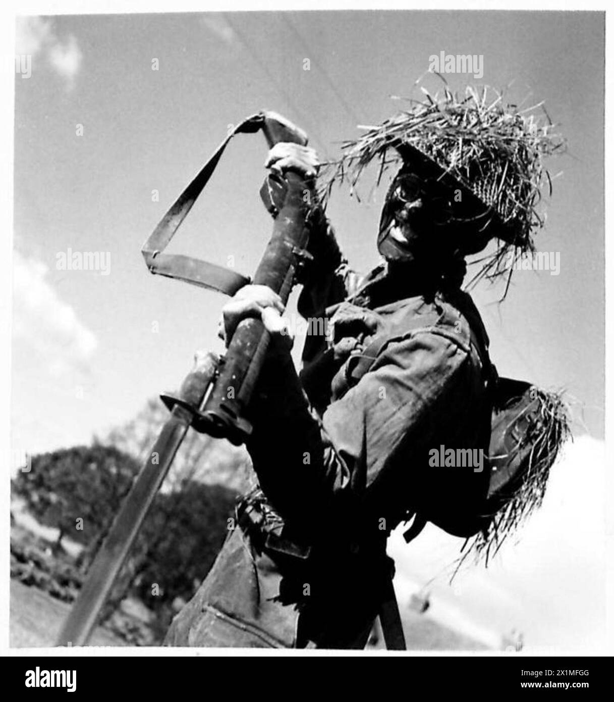 PIONEER CORPS BATTLE COURSE - With his face blackened and his helmet ...