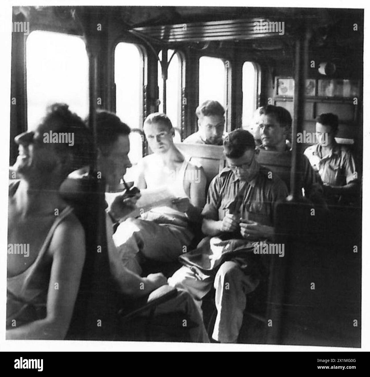 ITALY : THIRD LEAVE TRAIN FROM MILAN - The scene in an O.Rs carriage. Some of the men look out of the carriage windows at the passing countryside, some read, and some just sleep. The journey from Milan to Calais takes 34 1/2 hours to cover, British Army Stock Photo