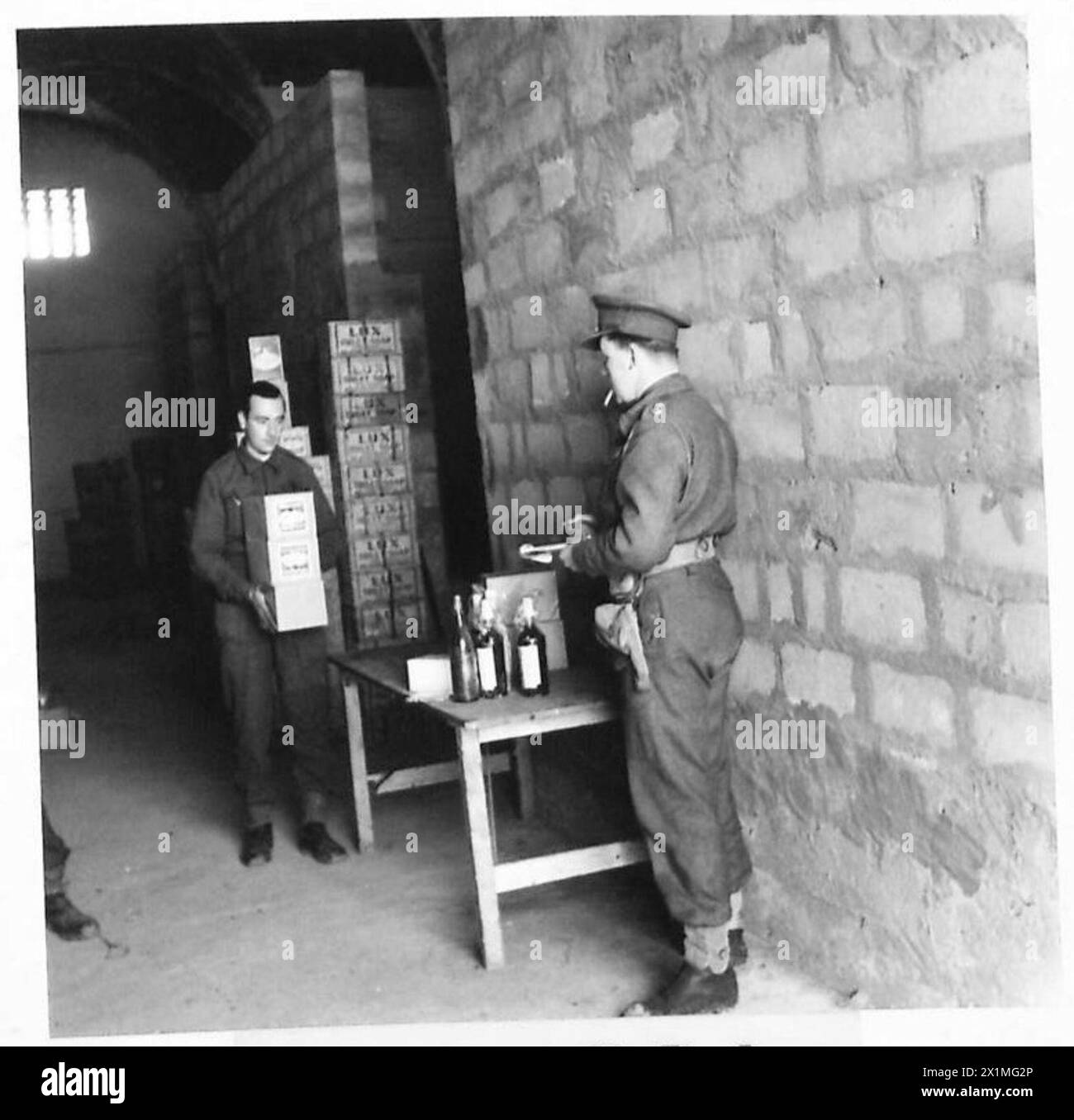 NAAFI SUPPLIES FOR FRONT LINE UNITS - An Officer checking off his order while being served, British Army Stock Photo