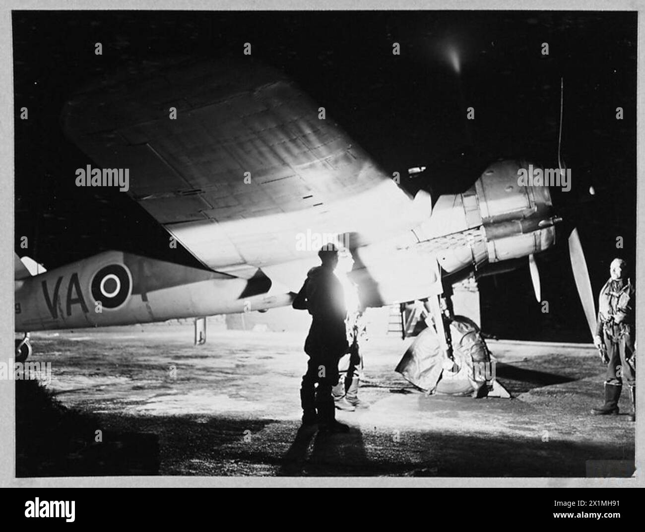 NIGHT BEAUFIGHTERS IN READINESS : - For introduction see CH.11180. Picture (issued 1943) shows - 2.00 a.m. Searchlights on! Covers are removed and crews stand by to take off in search of a single enemy aircraft, Royal Air Force Stock Photo