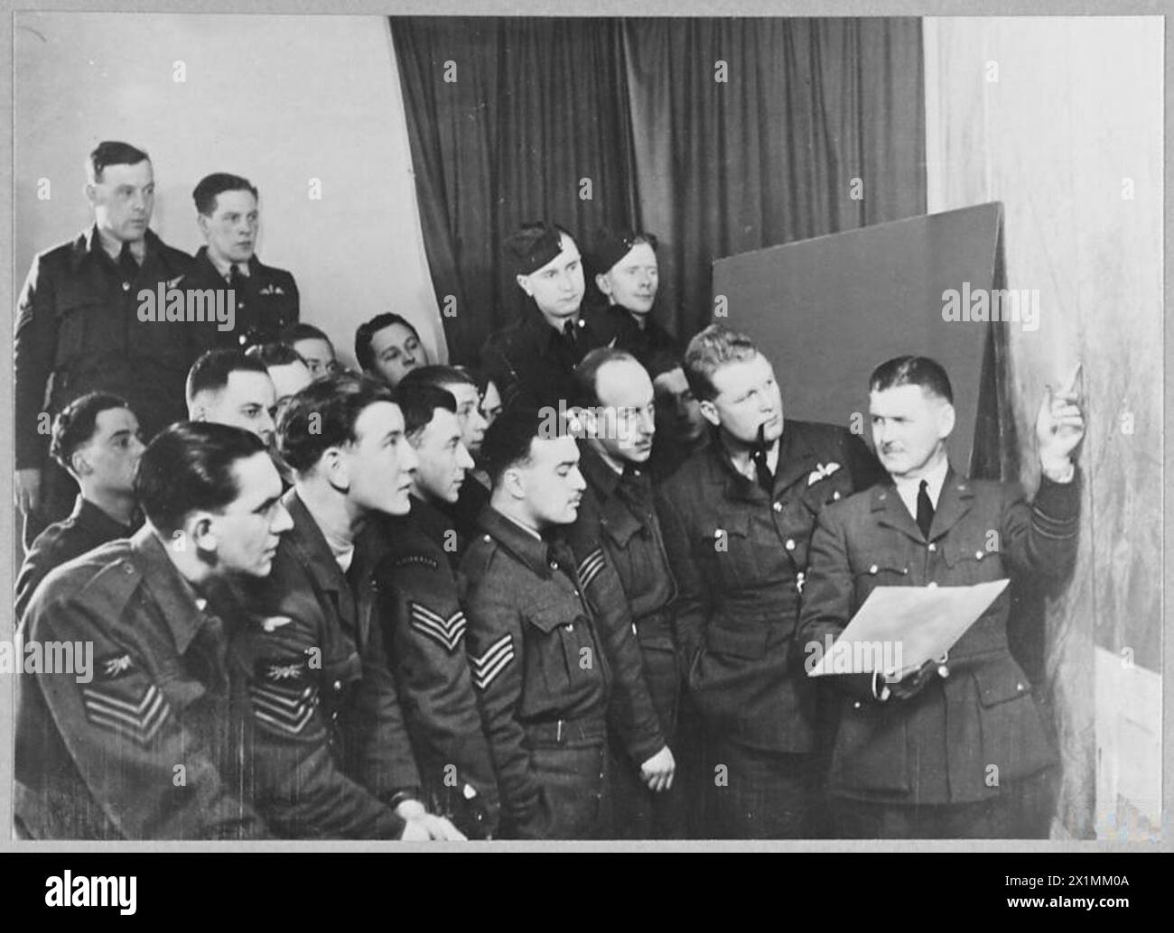 Bomber sergeants receive a briefing from the Intelligence Officer about ...