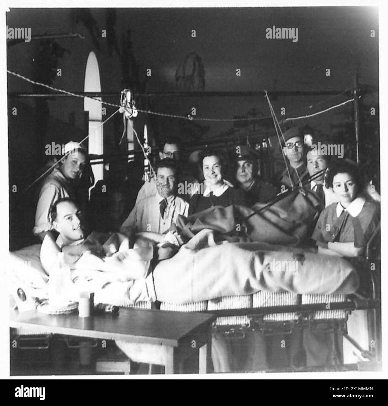 CHRISTMAS AT 104 BRITISH GENERAL HOSPITAL : OBSERVER STORY - Left to right:- Sgt. C.H. Robson, Grenadier Guards of 36 Rosalind Street, Ashington, Northumberland VAD Isuelt Passy of St.Anta, Carris Bay, Cornwall. Pte. J. Davies, R.A.S.C., of Astra, Thompson Avenue, Newport, Mon. Pte. E.J. Wall, R.A.M.C., of 15 Brynteg Avenue, Pontllanfriath, near Newport, Wales. Miss Thurza Crighton of Endymion Road, Hatfield, Herts Padre J.C.H. Gould of Weymouth, Dorset. Lieut James Nicol, R.A.M.C., of St.Clair, Milton Road, Kirkcaldy, Fife, SCotland Sgt. J. Gallagher, Para. Bde., home address, Belview Gate Lo Stock Photo