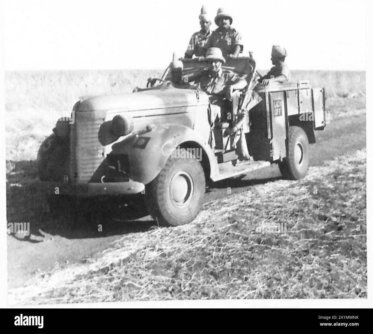 THE BRITISH ARMY IN NORTH AFRICA AND THE MIDDLE EAST 1940-1947 - On the road. Capt. ------ pictured in the Desert with his truck and staff, British Army Stock Photo