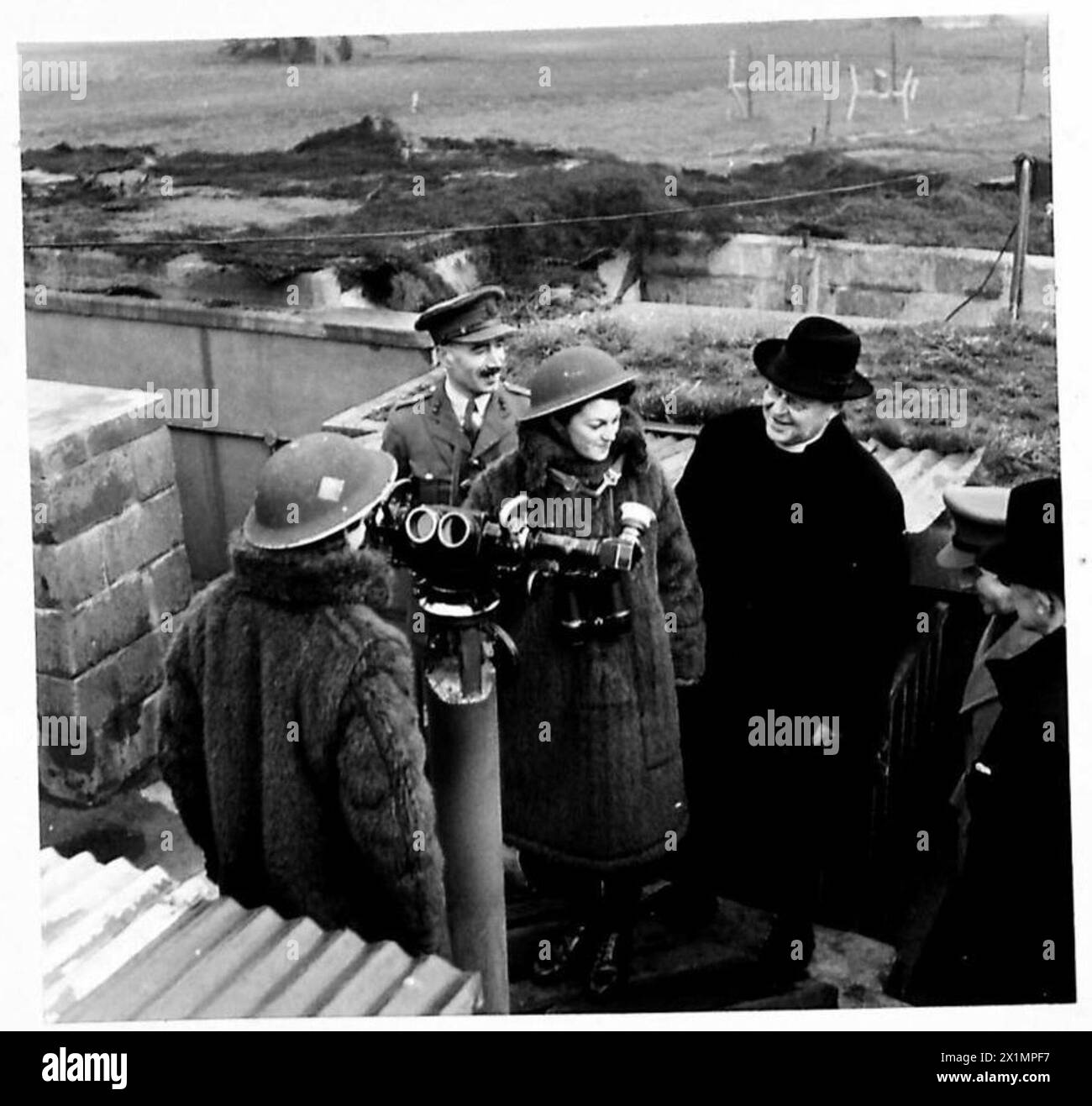 ARCHBISHOP OF CANTERBURY VISITS LONDON�S A.A. DEFENCES - His Grace the Archbishop of Canterbury chatting to Private Lily Harrett aged 20 of Leicester and Pte. Doris Shailham aged 20 of Barnsley, Yorks, who are spotters on a Mixed Heavy A.A. gunsite in the London area, British Army Stock Photo