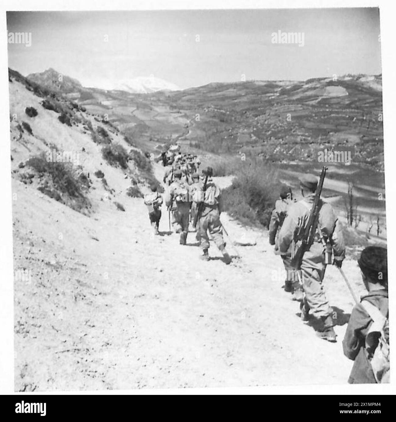 ITALY : AN APPENINE PATROL - The patrol climbs steadily upwards into the Appenines. The steep path is strewn with rocks and several stops are called by the patrol commander, British Army Stock Photo