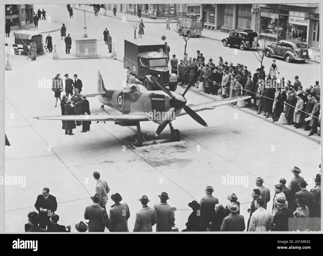 R.A.F. EXHIBITION AT ZURICH, SWITZERLAND - A Spitfire aircraft with an outstanding operational record was 'On Parade' at the Royal Air Force Exhibition which was held at the large departmental store of 'Jelmoli' in the main street of Zurich, Switzerland. Swiss Army and Air Force officers, as well as the public attended the opening ceremony, which was performed by Air Marshal Sir Arthur Coningham, KCB.,DSO.,MC.,DFC. Chief of Flying Training Command. February 1946. The operational 'Spitfire' outside the Exhibition, Royal Air Force Stock Photo