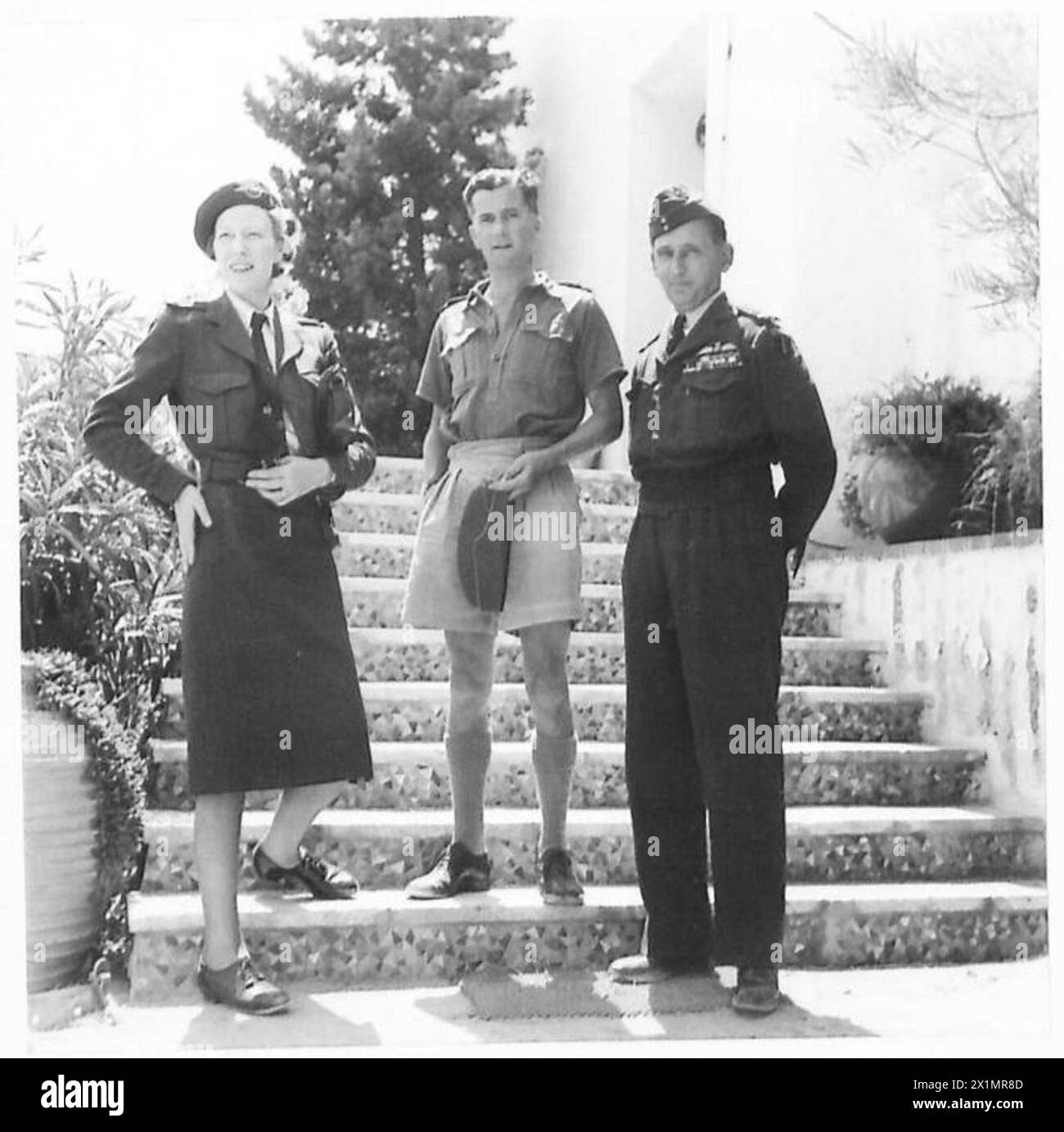 AIR CHIEF MARSHAL TEDDER VISITS ATHENS - Air Chief Marshal Tedder and his wife pose for a photograph on the steps of the A.O.C's house outside Athens. Air Commodore Tuttle is in the centre, British Army Stock Photo
