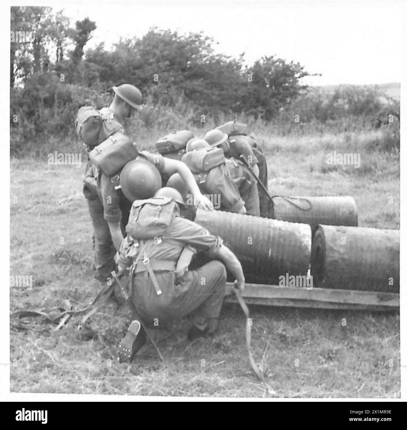 Soldier cyclists construct a raft in preparation for a river crossing ...