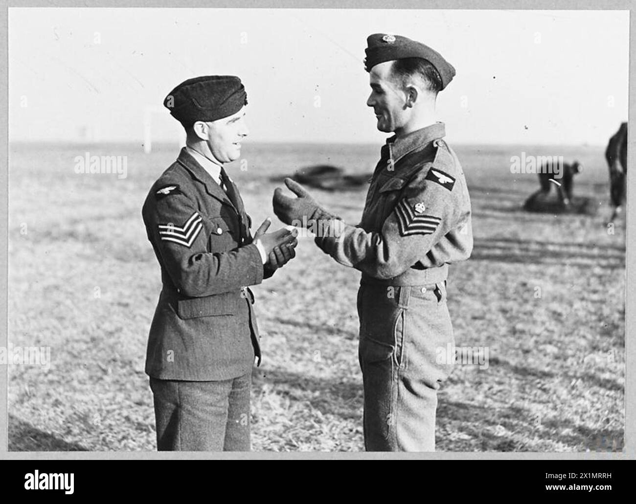 R.A.F. TO GUARD AERODROMES - 4570 RAF sergeants, on the left in their ordinary uniform and right - wearing a battle dress. The dress is khaki, with Air Force blue cap, Royal Air Force Stock Photo