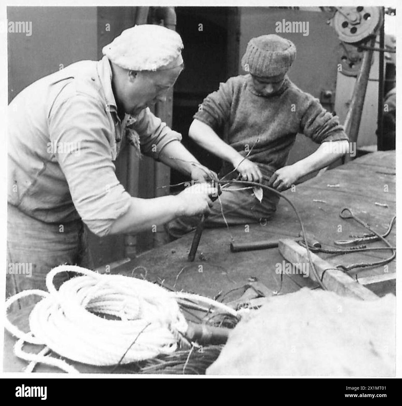 Crew members perform wire rope splicing aboard an African-bound convoy ...