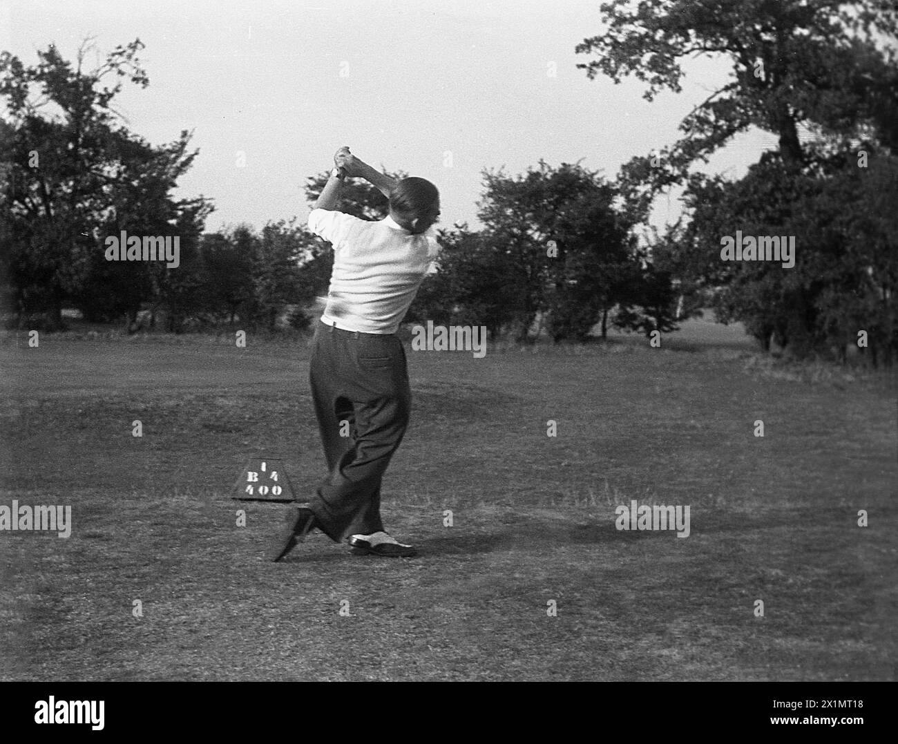 1950s, historical, an adult male golfer striking a ball off the tee on an inland golf course, England, UK. Stock Photo