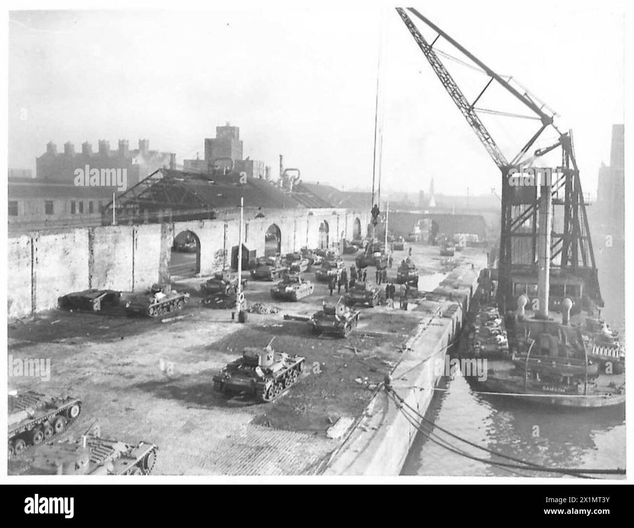Tanks are loaded onto a travelling crane ship, moved alongside a transport vessel, and reloaded for shipment to Russia, British Army. Stock Photo